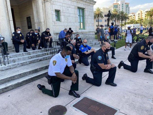 Policías hincados de rodillas en la ciudad de Miami, para rezar y pedir disculpas por la muerte de George Floyd, un gesto en que grupos de agentes han repetido en muchas ciudades de Estados Unidos. Foto: Franklin White/Twitter