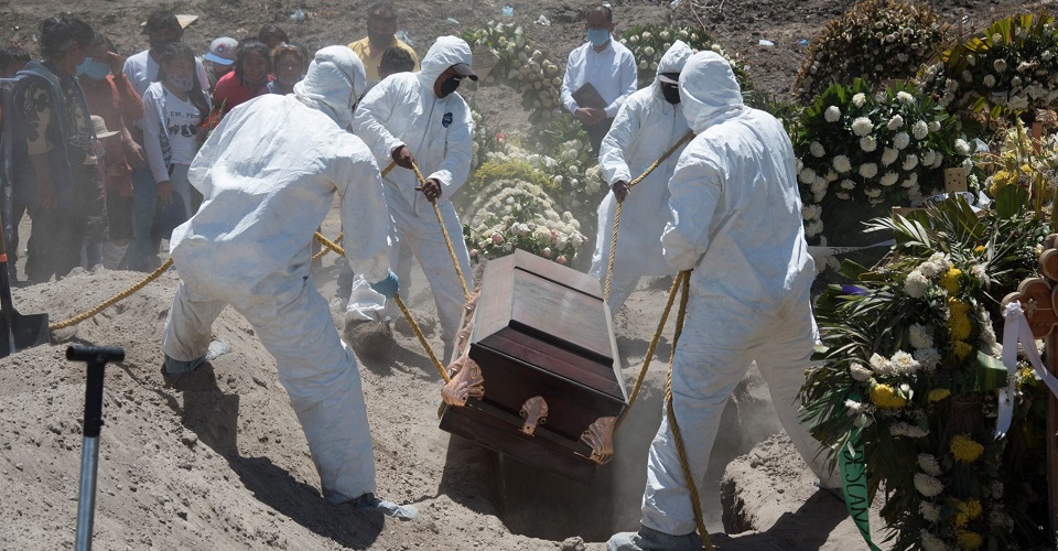 Familiares asisten al Panteón de Municipal del Valle de Chalco para dar el último adiós a un ser querido quien falleció por covid-19. Durante la inhumación trabajadores portan trajes Tyvek como forma de prevención.